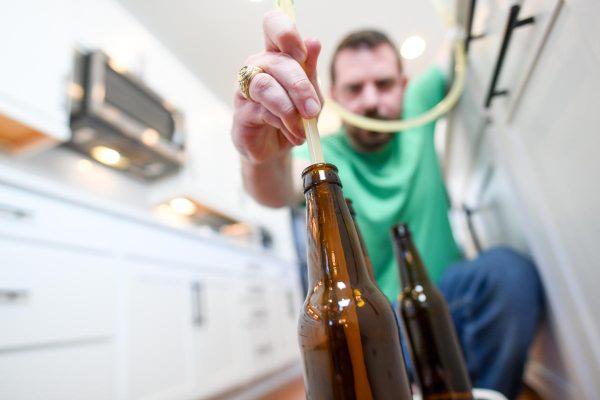 person filling bottles with homebrewed beer