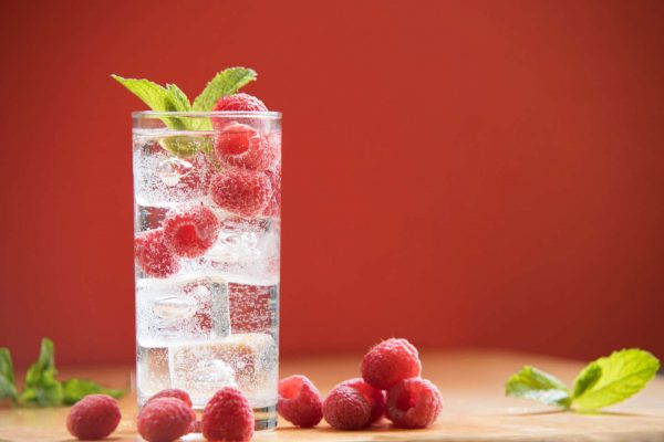 hard seltzer in a glass with berries