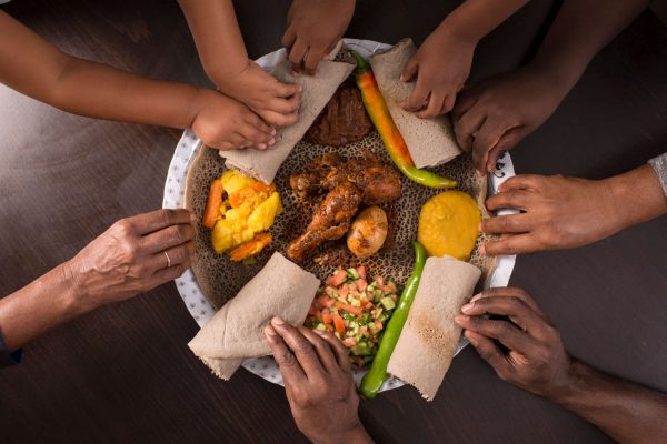 Ethiopian traditional hand held eating injera.