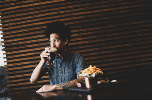 man drinking beer at pub