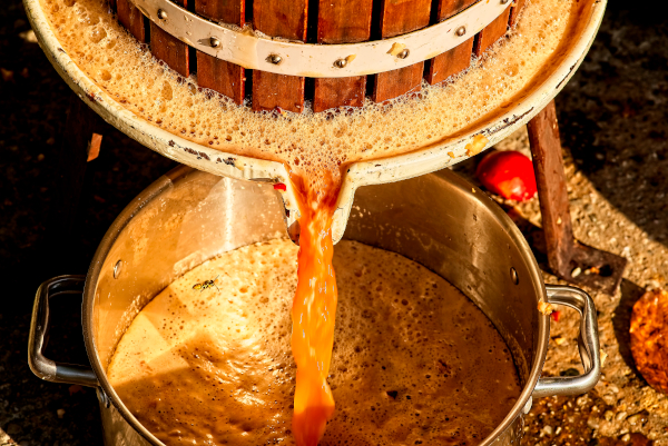 apple press with juice pouring out