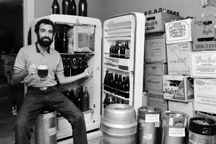 Charlie Papazian in front of beer fridge