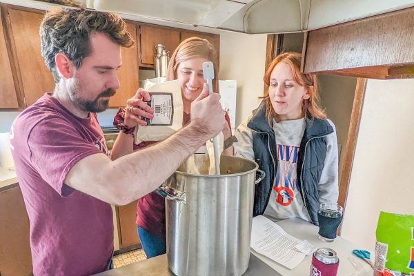 trio of homebrewers by a brew pot