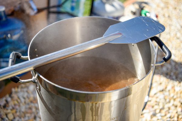 mash paddle resting atop a homebrew pot